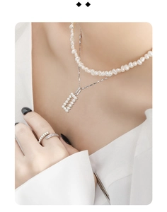 Detail of a double-layer silver necklace with rectangular pearl and matching open ring