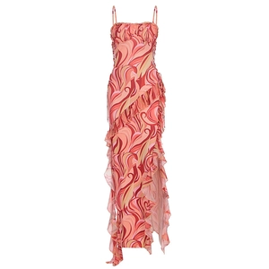 Detail of bohemian spaghetti strap dress featuring orange swirl print and ruffled high slit