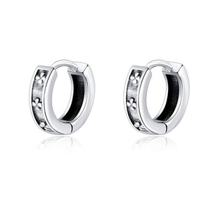 Macro detail of silver lightning earrings with purple zircon and engraved floral patterns