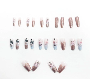 Detailed view of floral press-on nails with cherry blossoms and glitter finish