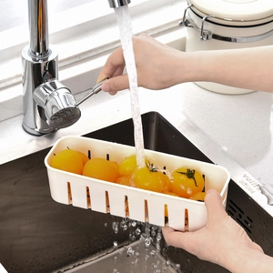 White rectangular plastic drain storage box with yellow tomatoes under running water