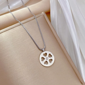 Macro shot of silver four-leaf clover pendant with center stone on jewelry display