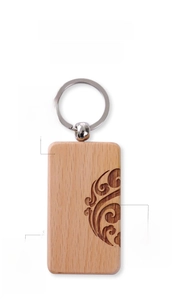 Detail of wooden keychain showing laser-engraved vintage cloud patterns and metal ring