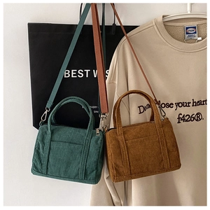 Detail view of green and brown corduroy mini Boston bags with detachable straps