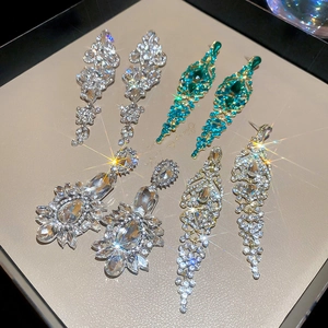 Detailed view of three pairs of sparkling long drop crystal tassel earrings in a jewelry tray