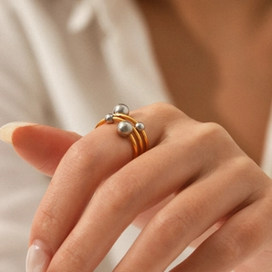 Close-up of three-layer mixed gold and silver ball ring on model's hand
