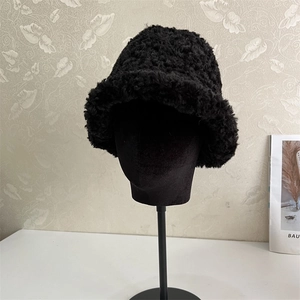 Close-up of black fuzzy lamb wool bucket hat with thick texture and retro style