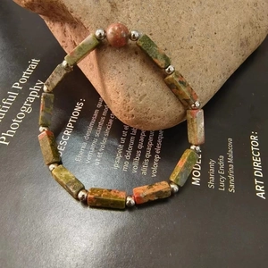 Detailed macro view of natural unakite stone beads with silver spacer accents on a bracelet