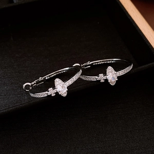 Detail shot of silver Saturn hoop earrings featuring oval zirconia on black velvet tray