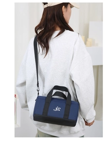 Rear view of a model wearing a stylish blue and black nylon pillow bag with JLP logo