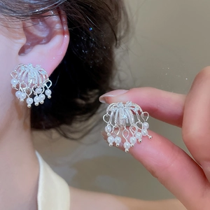 Detail shot of zircon firework earrings with white pearls and 18k silver plating