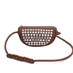 Brown half-moon rivet shoulder bag with silver studs and woven strap on white background