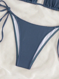 Close-up of dark blue honeycomb texture bikini bottom with adjustable side ties
