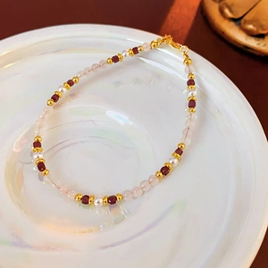 Detail of 18K gold plated bracelet with pearls, ruby red beads and crystal accents