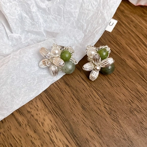 Detail view of silver floral earrings with white pearls and green agate beads