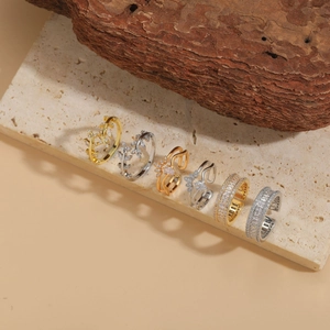 Dettaglio di anelli assortiti con zirconi in finitura oro e argento stile ramo naturale
