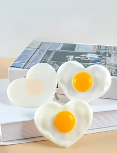 Macro shot of realistic heart-shaped fried egg model with detailed white and yolk texture