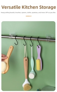 Kitchen setup showing black S-shaped metal hooks hanging cleaning brushes on a rod