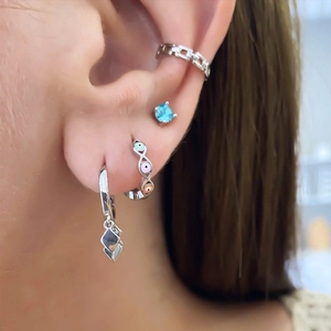 Detailed shot of S925 silver evil eye hoop earrings with blue gemstone stud and ear cuff