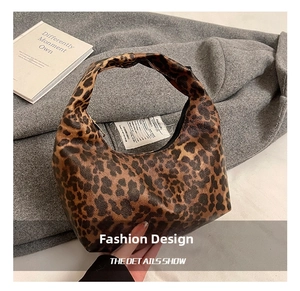 Détail de la texture léopard du sac à main et fermeture éclair sur laine sombre