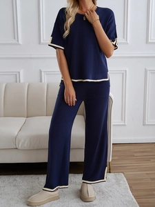 Detail view of navy blue knit set featuring short sleeve top and wide-leg trousers trim