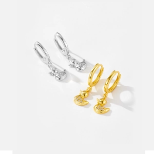 Detail of silver and gold duck earrings with sparkling cubic zirconia on white background