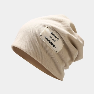 Close-up of beige knit beanie featuring vintage style Season 13 canvas patch detail