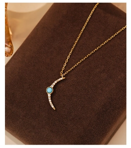 Detailed macro of gold S925 silver necklace with turquoise moon pendant and zircons