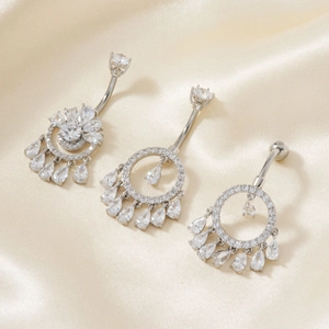 Detailansicht silberner Bauchnabelpiercings mit Zirkonia-Wassertropfen-Anhängern auf Seide