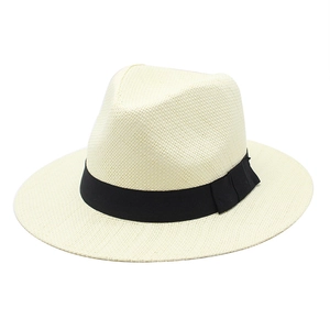 Detail of cream straw fedora hat featuring a fine weave and minimalist black ribbon band