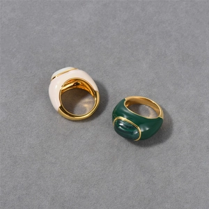Detail of 18k gold plated rings featuring natural malachite and white mother of pearl