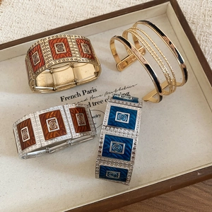 Detailed view of vintage square enamel stretch bracelets in gold and silver metal frames