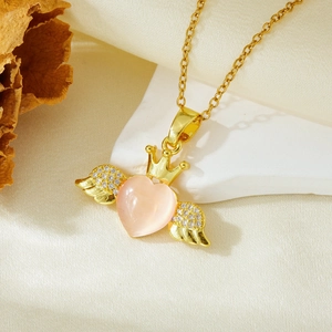 Detail of pink heart pendant with gold crown and angel wings on a gold chain