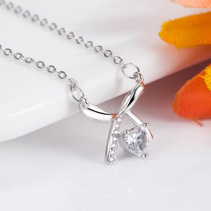 Exquisite bow and heart crystal necklace with silver chain on clean white background