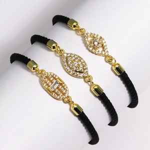 Set of three black woven evil eye bracelets with gold accents and cubic zirconia