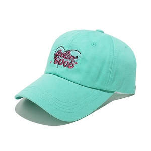 Detail view of mint green baseball cap featuring pink 'feelin' GOOD' heart embroidery