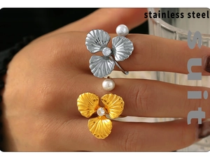 Detail of 18k gold and silver stainless steel rings with pearl and zircon flower motif