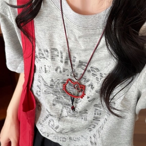 Collier avec pendentif chat rouge et cordon noir présenté sur le cou d'un mannequin