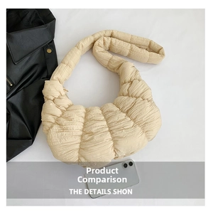 Detail of beige quilted cloud bag texture and padded strap with phone for scale