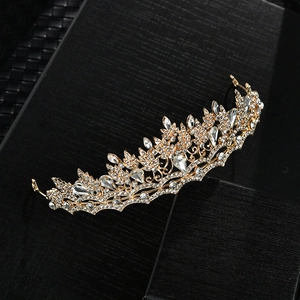 Golden Baroque bridal crown with crystals on a black display box for wedding hairstyles
