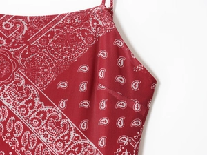 Detail of red paisley print on breathable mesh fabric with vibrant summer dress texture