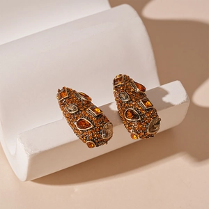 Retro geometric drop earrings with amber and champagne crystals on white stand