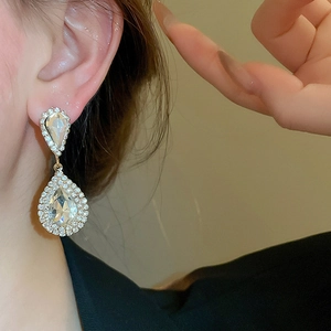 Close-up of sparkling pear-cut crystal drop earrings worn for an elegant luxury look