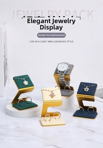 Detail of luxury emerald velvet jewelry display stand with golden Z-shaped metal frame
