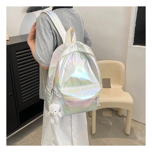 Rear view of a laser holographic silver backpack with a plush bear charm accessory