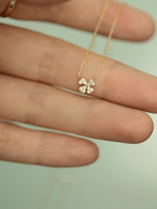 Macro detail of 925 sterling silver four-leaf clover pendant with pavé diamonds on fine chain