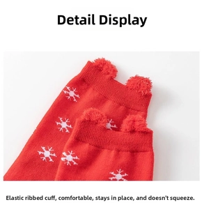Close-up of elastic ribbed cuffs on red Christmas socks with white snowflake patterns