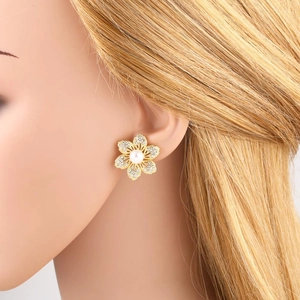 Pendientes dorados de flor con perla central y cristales brillantes en maniquí