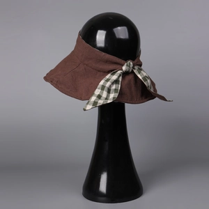Detail view of dark brown linen sun visor with green and white plaid bow decoration