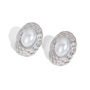 Close-up of vintage oval silver earrings featuring a large central pearl inlay